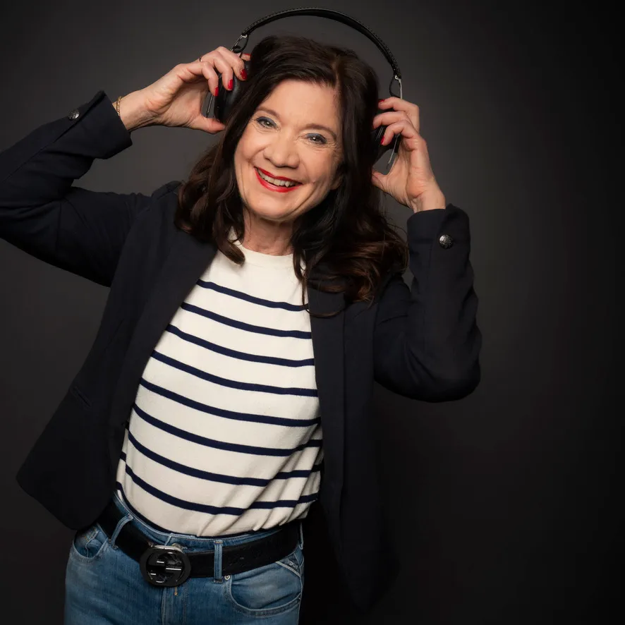 Susann Reckeweg lächelt mit Kopfhörern im Studio